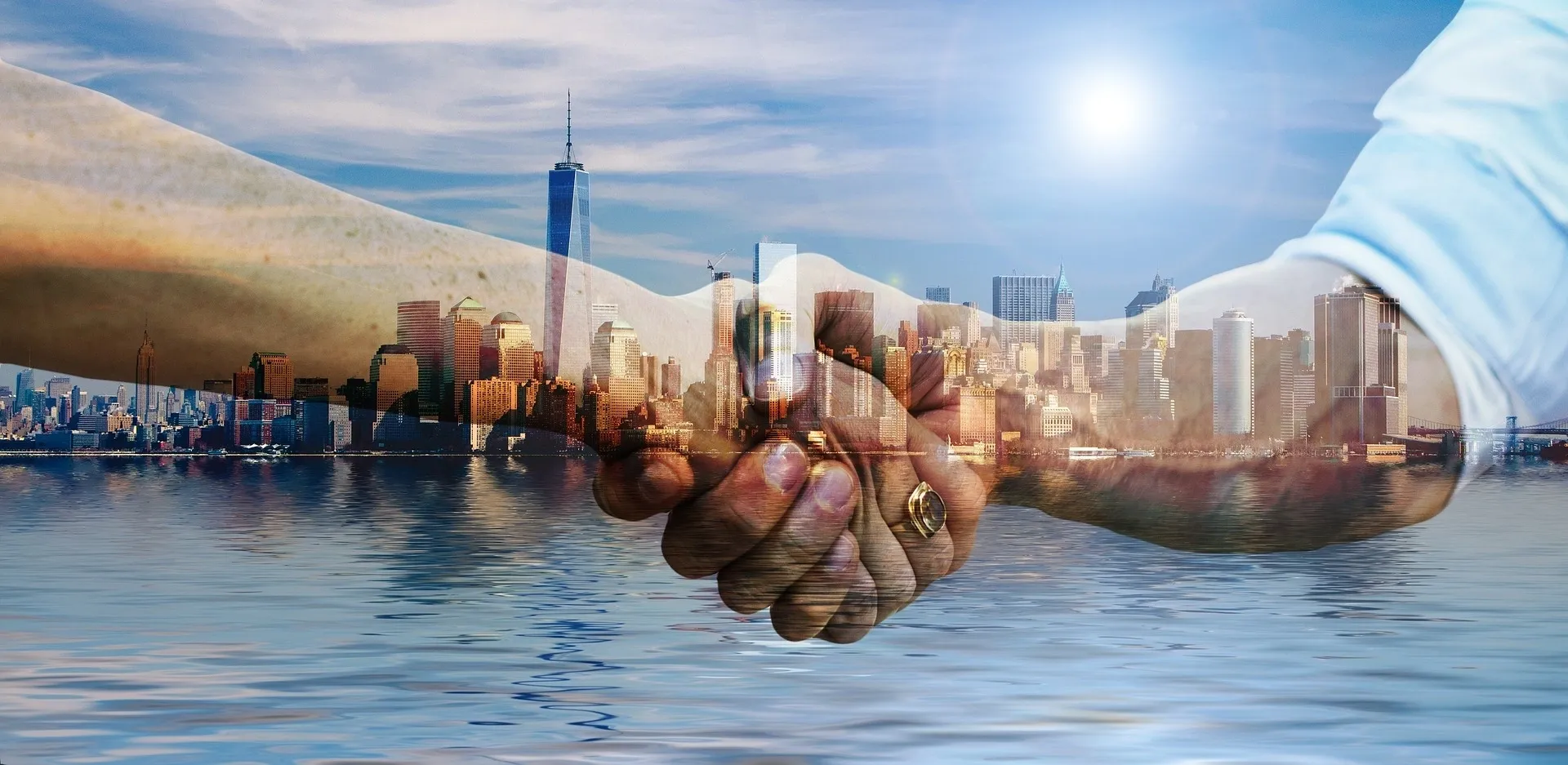 Two hands holding each other in front of a city skyline.